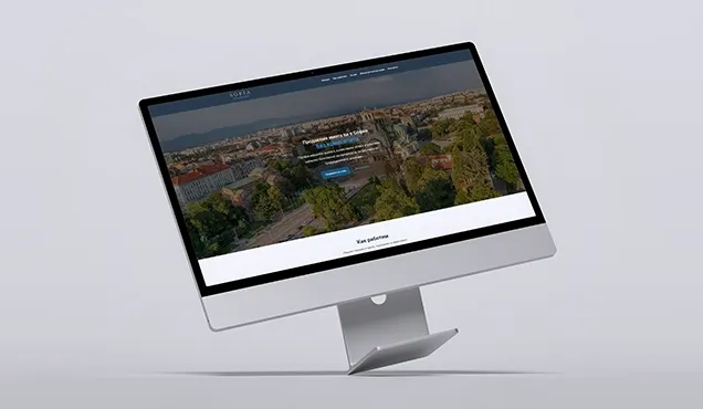 Landing страница за имотен проект в София, показана на наклонен настолен монитор с градски фон и форма за контакт